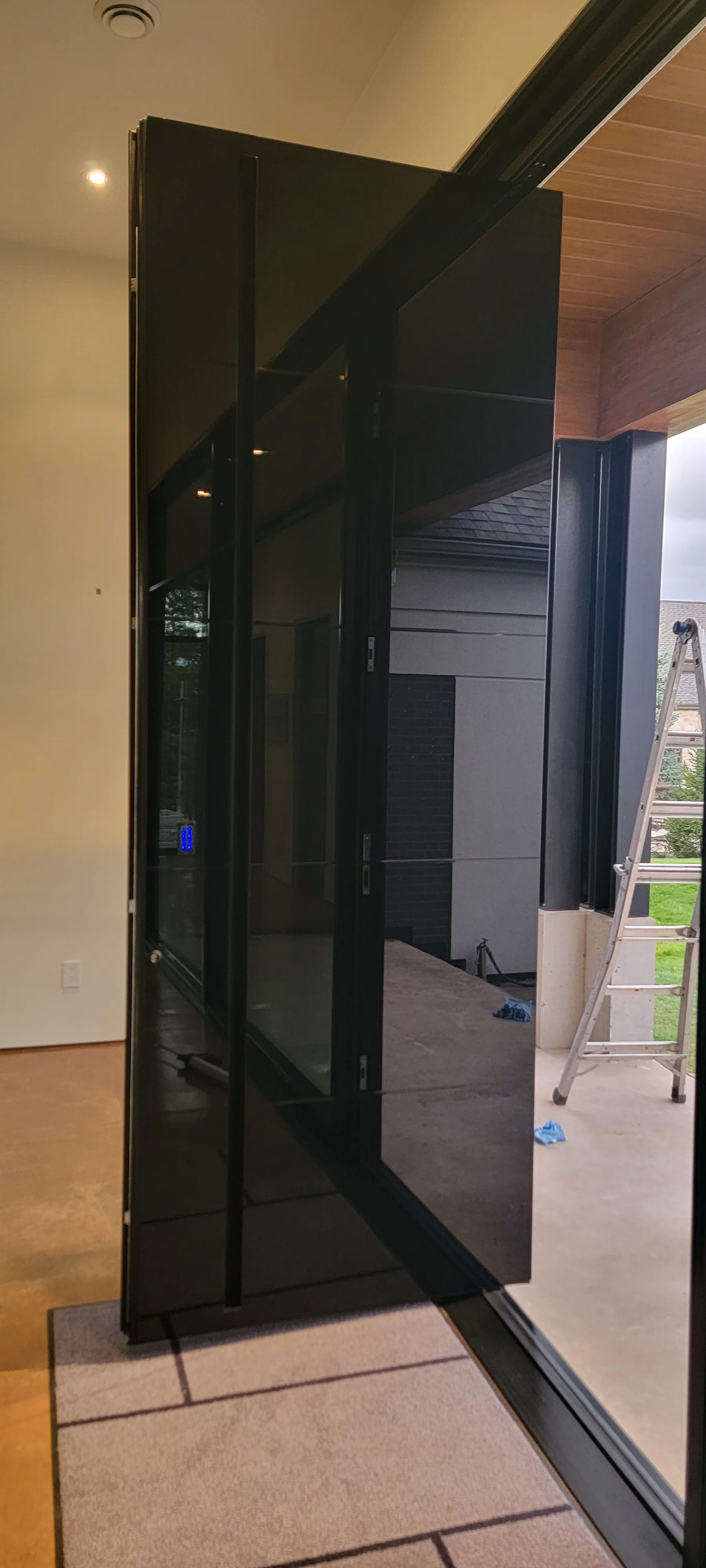 Matte black pivot door installed by Better View on a modern custom home